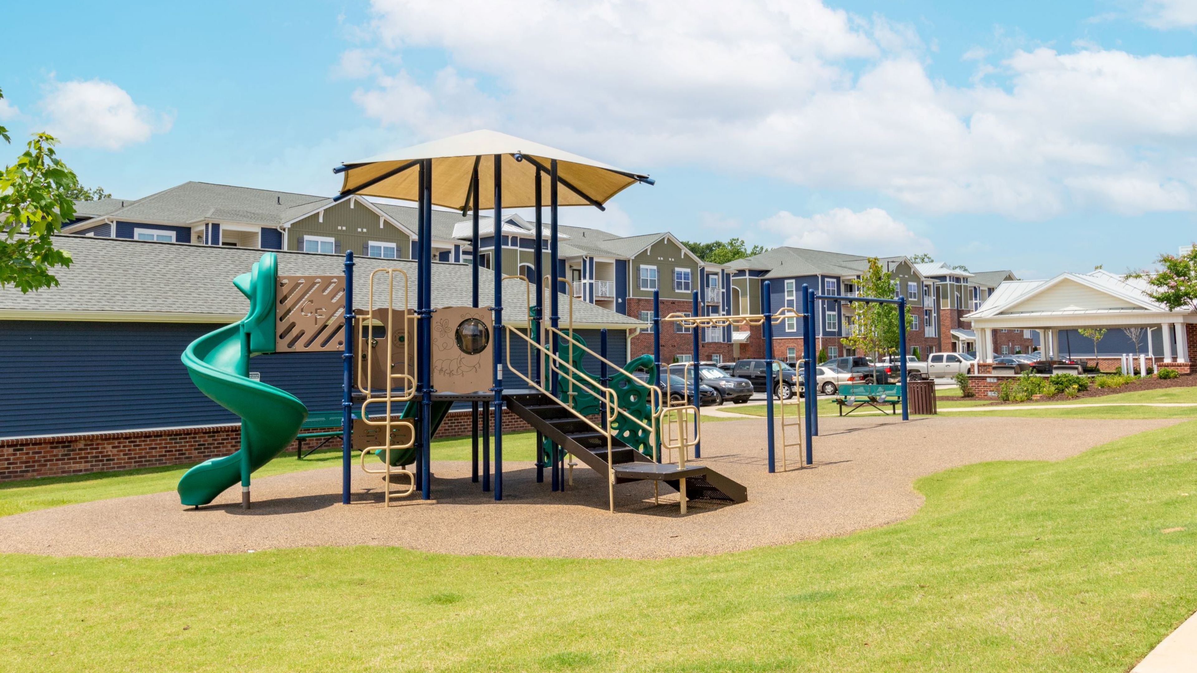 Hawthorne at Simpsonville apartments community exterior with large green lawn and jungle gym