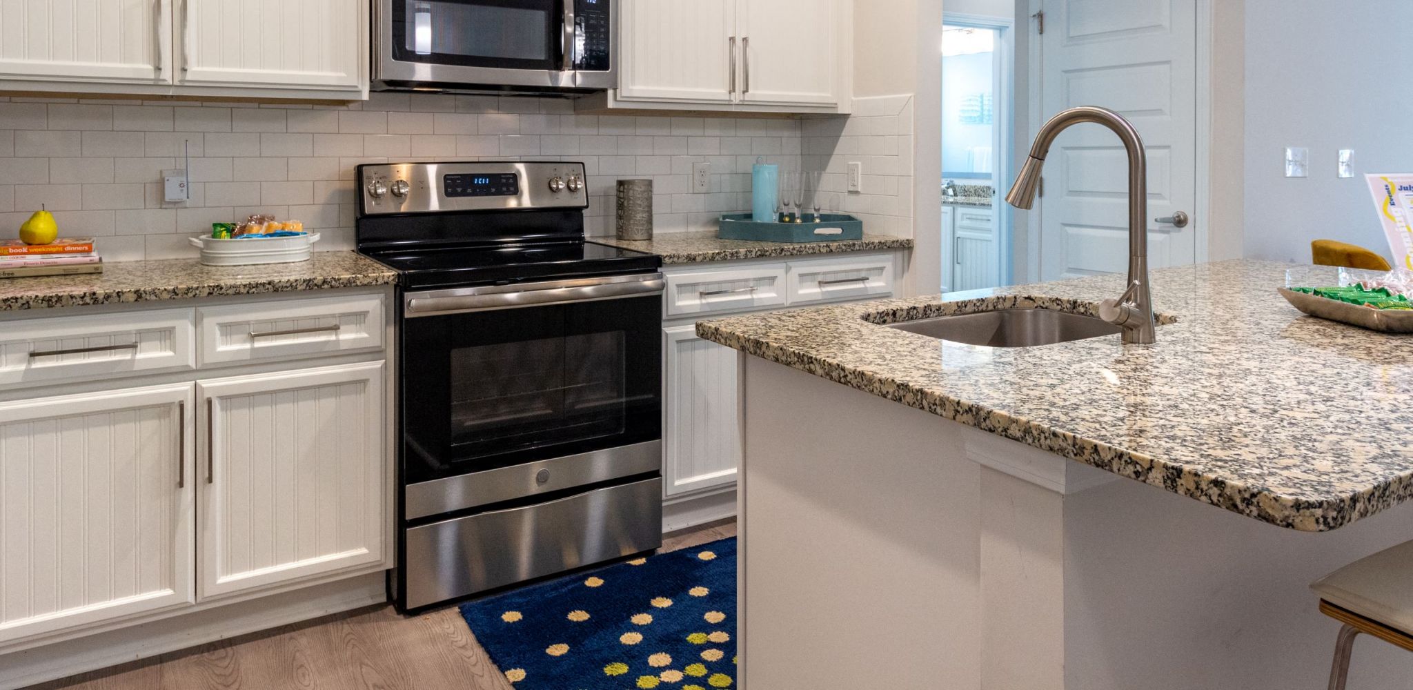 Hawthorne at Simpsonville apartment kitchen interior with kitchen island, stainless steel appliances, and custom cabinetry
